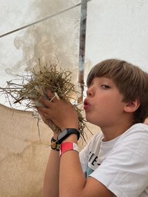 Ein Junge pustet Feuer an